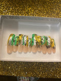 Tropical green and yellow almond press-on nail set with black botanical leaf nail art